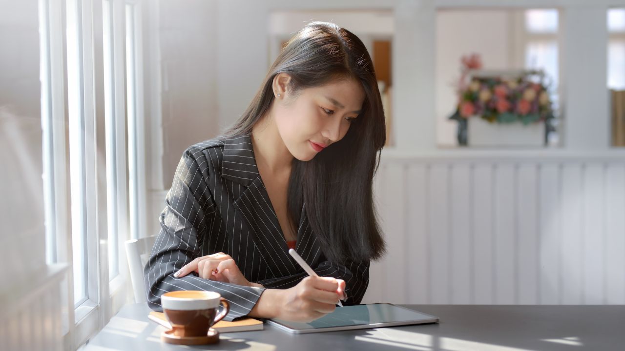 Woman writing on ipad